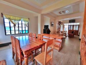 a dining room with a wooden table and chairs at Sagada Staycation with Mountain View! in Sagada