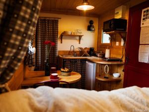 a small kitchen with a table in a room at Roulotte - Etat Nature in Magnières