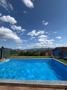 a large blue swimming pool with a blue sky at BoomBoom Room in Cazin