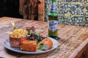 a table with a plate of food and a bottle of beer at The Seaton Lane Inn - The Inn Collection Group in Seaham +51 photos
