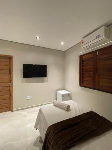 a bedroom with a bed and a flat screen tv at Pousada Na Serra in Ubajara