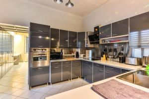 a kitchen with stainless steel cabinets and stainless steel appliances at L'atypique - Piscine intérieure - Wifi in Challans