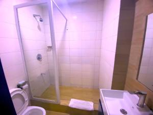 ein Badezimmer mit Dusche, Toilette und Waschbecken in der Unterkunft Hotel Capitol in Ikeja + 127 Fotos