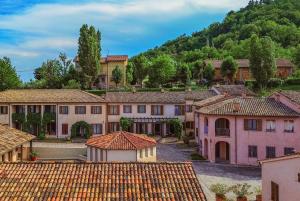 a village with a mountain in the background at Borgo degli Ulivi - Castello di Montegridolfo in Montegridolfo