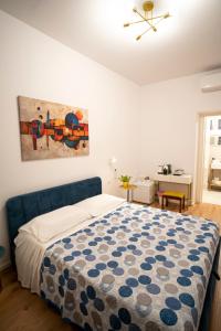 a bedroom with a bed and a painting on the wall at Domus Mirea in Aquiléia