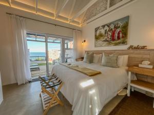 a bedroom with a bed with a view of the ocean at Seeplaas Guesthouse in Great Brak River