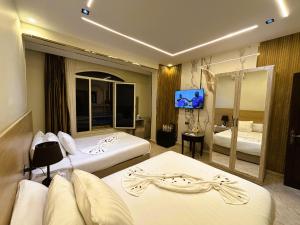 a hotel room with two beds and a flat screen tv at Pyramids Nun INN in Cairo +75 photos