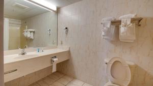 a bathroom with a toilet and a sink and a mirror at Ocean 1 Hotel & Suites Ocean City in Ocean City +33 photos