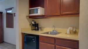 a kitchen with a sink and a microwave at Ocean 1 Hotel & Suites Ocean City in Ocean City