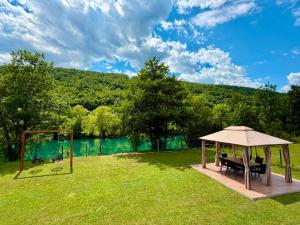 ein Pavillon mit Tisch und Stühlen auf einem Feld in der Unterkunft Aquaverde in Orašac + 14 Fotos