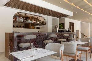 a restaurant with tables and chairs and a bar at Nesean Plaza Hotel in Heraklio