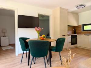 eine Küche und ein Esszimmer mit einem Tisch und grünen Stühlen in der Unterkunft Aquaverde in Orašac