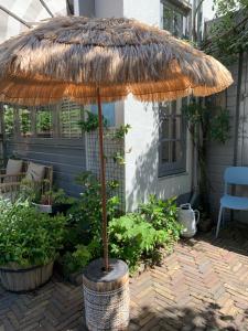 a large straw umbrella sitting on a patio at Appartement 't Loft in Zandvoort