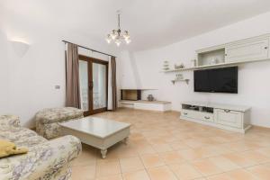 a living room with a couch and a tv at Villa Lu Nibaru 2 in Cannigione