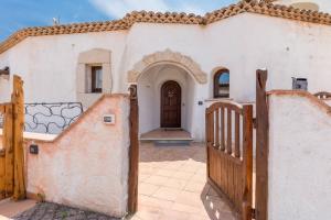 a house with a wooden gate and a door at Villa Lu Nibaru 2 in Cannigione
