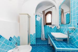 a blue tiled bathroom with a sink and a mirror at Villa Lu Nibaru 2 in Cannigione +28 photos