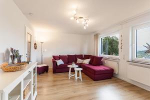 a living room with a red couch and a table at Ferienwohnung Grübel in Kirchhundem