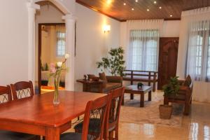 a living room with a wooden table and chairs at Lullaby Marine Villa in Wadduwa