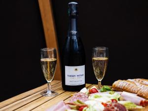 two glasses of champagne next to a bottle of wine at Bulle nuage - Etat Nature in Magnières