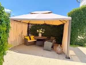 Ein Tisch und Stühle unter einem weißen Sonnenschirm in der Unterkunft Grand Petit Hotel in Prag
