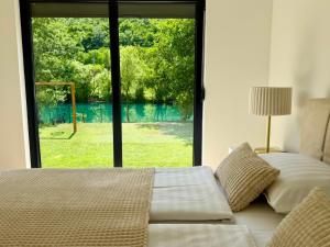 ein Schlafzimmer mit einem Bett und einem großen Fenster in der Unterkunft Aquaverde in Orašac