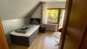 a small room with a bed and a window at Gasthof Walhalja in Schmallenberg