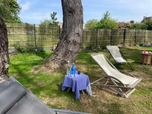 a table and two chairs next to a tree at Ty Glazu Doelan espace 60m2, Port& criques à pied, 2 chambres privées au 1er étage, SDB, WC séparé in Clohars-Carnoët