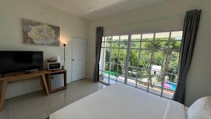 a bedroom with a bed and a large window at Greenery Hill in Ban Nok