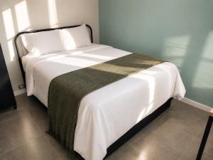 a bedroom with a large bed with white sheets at Studiohaus Alvorada in São Paulo