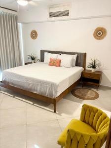 a bedroom with a bed and a yellow chair at Aligio Beachfront Paradise in Las Terrenas +35 photos