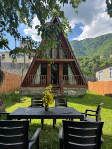 a table and chairs in front of a house at Cozy Cottage JuFu in Mestia
