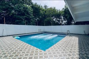 a swimming pool with blue water in a backyard at Sunlux Villa in Pondicherry