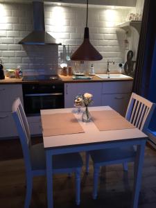 a kitchen with a table with a vase of flowers on it at Chez Sven - Studio 'Le Grand' in Lohn-Ammannsegg