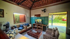 a living room with a couch and a tv at Xodó da Lagoa in Beberibe