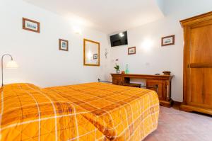 a bedroom with a bed with an orange blanket at Il Giardinetto Rooms in Ferrara