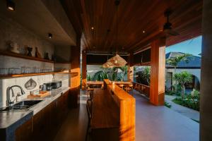 a kitchen with wooden cabinets and a large window at Casa Nova Villa Uluwatu in Uluwatu