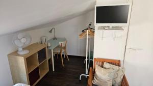 a room with a desk with a tv and a table at Maison Corcovado in Paray-le-Monial