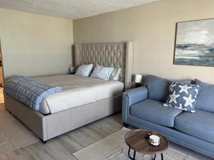 a bedroom with a bed and a couch at Luxury Beach Condos with Pool and Tiki Bar! in Daytona Beach +51 photos