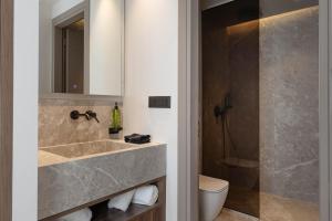 a bathroom with a sink and a toilet and a mirror at Nesean Plaza Hotel in Heraklio +48 photos
