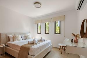 a white bedroom with a bed and a couch at Oroklini Hills Modern Sea View Apartments in Oroklini +21 photos
