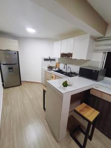 a kitchen with a white counter and a refrigerator at Quiet place in El Seis