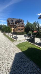 a large house with a building in the background at Hotel Kukučka Apartament C102 Tatranská Lomnica in Vysoké Tatry