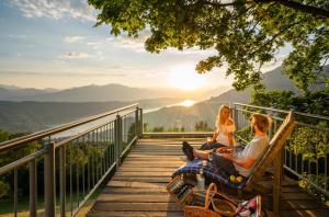 a couple sitting on a deck watching the sunset at Appartement Kochen in Döbriach