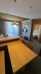a large wooden table in a room with a bedroom at Hotel Kukučka Apartament C102 Tatranská Lomnica in Vysoké Tatry