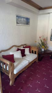 a wooden couch with pillows on a room with a wall at Hotel Kukučka Apartament C102 Tatranská Lomnica in Vysoké Tatry