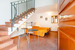 a room with a table and chairs and a staircase at Il Giardinetto Rooms in Ferrara