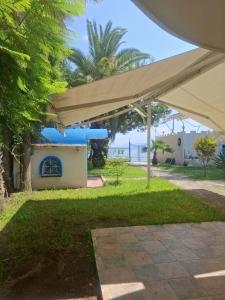 a patio with awning and the ocean in the background at Διαμερισμα επάνω στο κυμα in Kineta