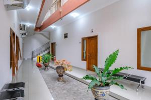 a corridor with potted plants in a building at RedDoorz at Syariah House Purwokerto in Purwokerto