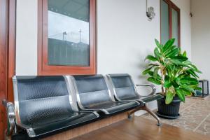 a black bench in a room with a potted plant at RedDoorz at Syariah House Purwokerto in Purwokerto