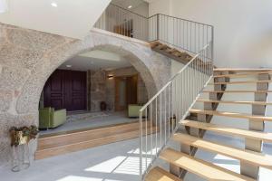 a staircase in a house with a stone archway at Casas do Bacelar by Liiiving in Quinchães +98 photos